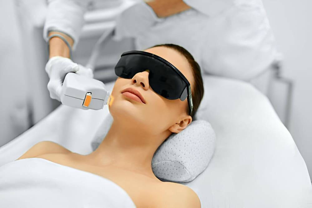 Light therapy completing a CACI microdermabrasion facial, protective eyewear in place