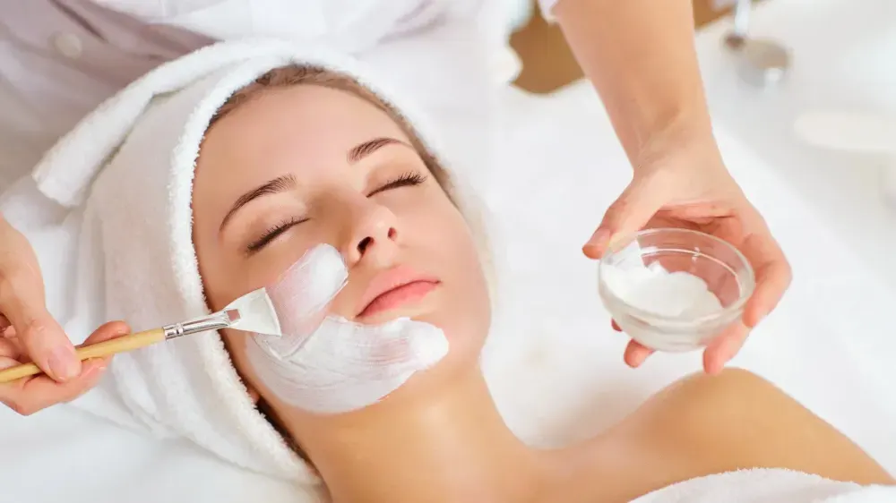 An anti-ageing treatment mask applied to the cheek with a fan brush